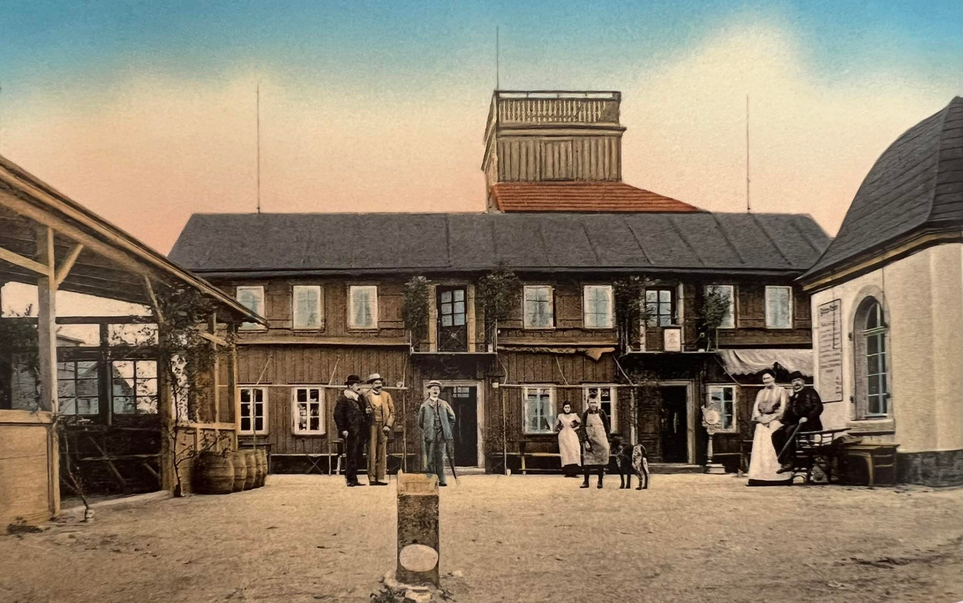 Lausche, Gesselschaftsplatz. Luž, cca 1900. Bývalá bouda z roku 1823 na vrcholu Luže, která byla státní hranicí rozdělena na českou a německou část. Dne 8. ledna 1946 byla chata zřejmě úmyslně zapálena a následně zcela zničena požárem. (archiv Eva Malíková)