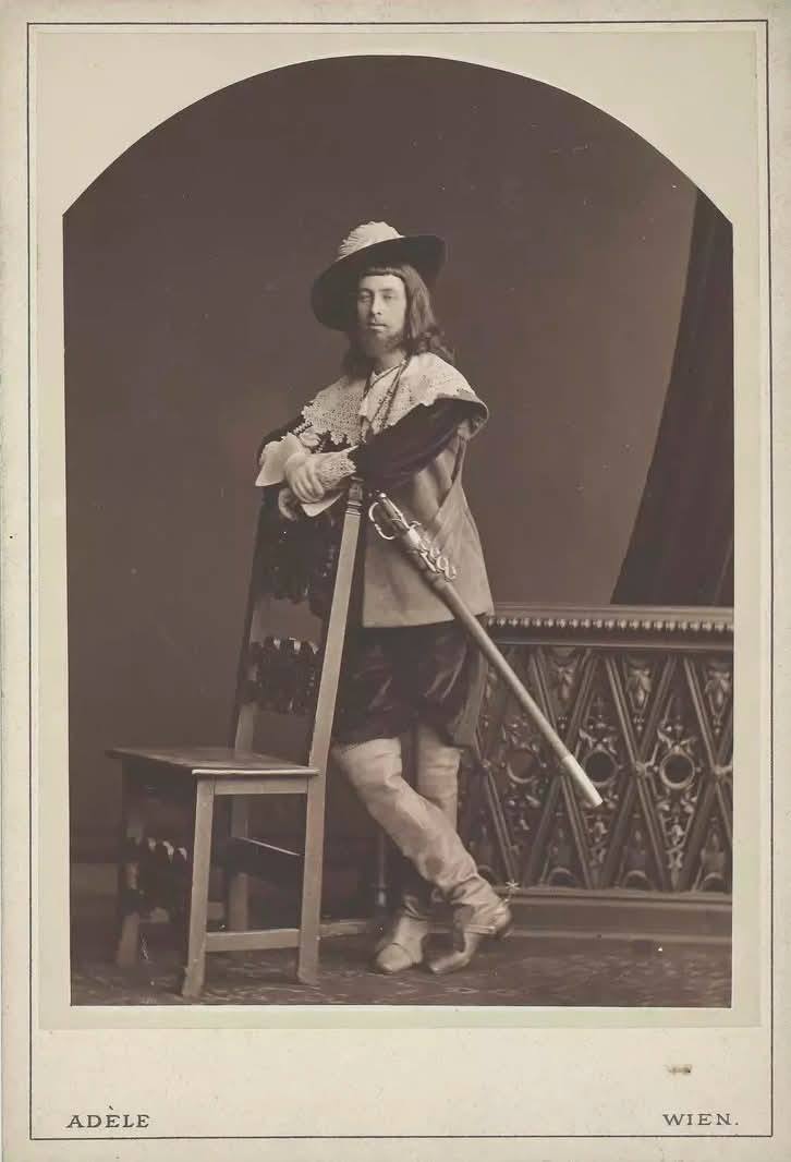 Malíř Hans Makart (1840–1884) na bílém koni při slavnostním průvodu.  Zdroj: Victor [auch: Viktor] Angerer (Photographer), Hans Makart (1840-1884), Maler, zu Pferde beim Festzug 1879, Gruppe "Künstler", 1879, Wien Museum Inv.-Nr. 47246, CC0