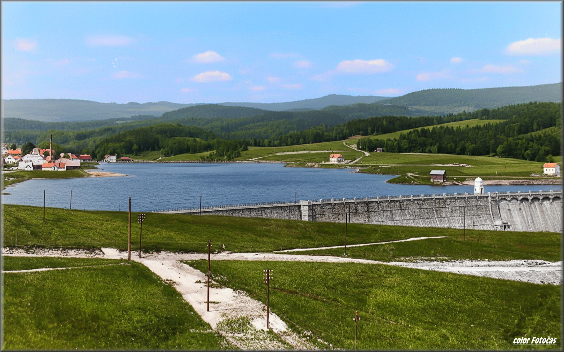 Fotografie zachycuje přehradu přibližně rok po dokončení (kolem roku 1910), včetně nové silnice ze Mšena do Pasek (původní byla zatopena), a v popředí je dnešní Saskova ulice, tehdy Gabelsbergerstrasse. color Fotočas Mirek