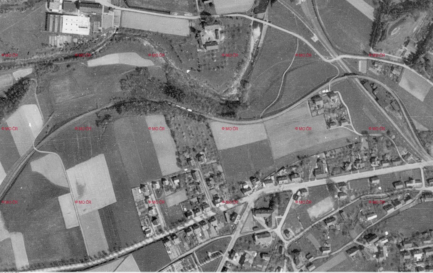 Archivní letecký snímek z roku 1938. Zachycen vláček Heřmaničky v jízdě před stanicí Rasl&syn. Zdroj: https://ags.cuzk.gov.cz/archiv/openmap.html? (archiv Aleš Procházka)