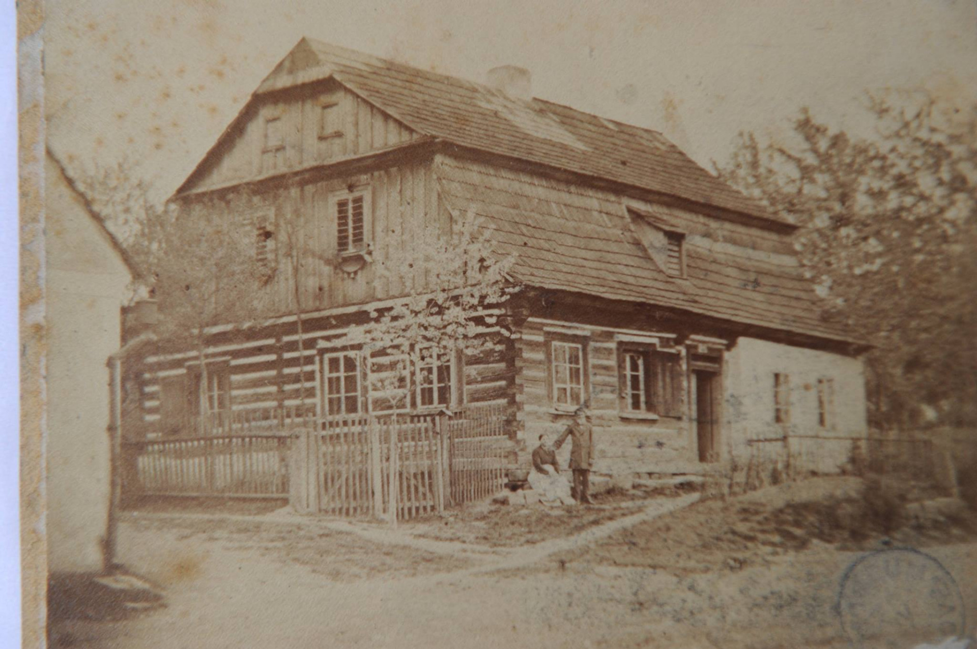 Dnes se podíváme na Havlíčkovo náměstí. 🤔😉 Na fotografii vidíte dům č. p. 19 z počátku 19. století, který do dubna 1973 stál v Turnově na rohu dnešního Havlíčkova náměstí a ulice 28. října. V 60. letech minulého století byl již poslední turnovskou stavbou představující typ roubeného městského domu. Obvodové zdivo bylo kombinováno kamenem s krytou verandou a mansardovou barokní střechou původně krytou došky. Repliku této zaniklé památky můžete dnes vidět v areálu Muzea Českého ráje. Vlevo je vidět část bývalé olejkárny, kde se lisoval olej do 60. let 19. století.  Zdroj: Muzeum Českého ráje