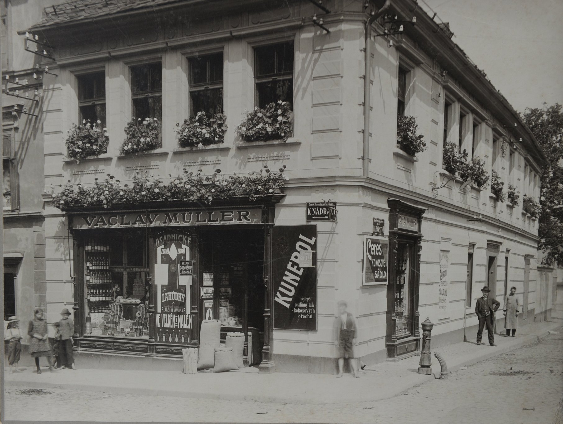 Na fotografii, která byla pořízena kolem roku 1900 se nachází obchod pana Václava Müllera. jedná o dům č.p. 472, tedy rohový dům na křižovatce ulic Palackého a Trávnice. Dnes je zde obchod s oblečením SAM 73. Zdroj: Muzeum Českého ráje v Turnově