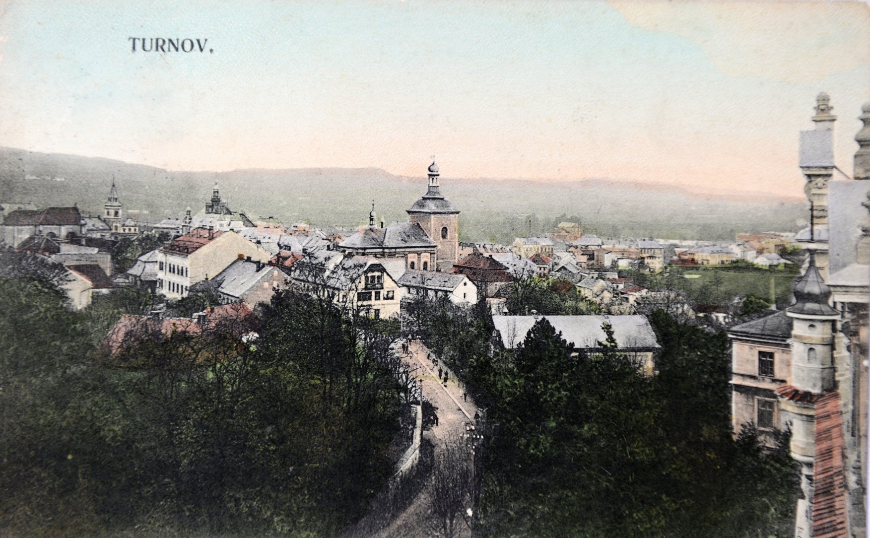 pohledem z budovy chlapecké školy směrem k náměstí. Tato kolorovaná dopisnice vznikla před r. 1918. Zdroj: Archiv Muzea Českého ráje v Turnově