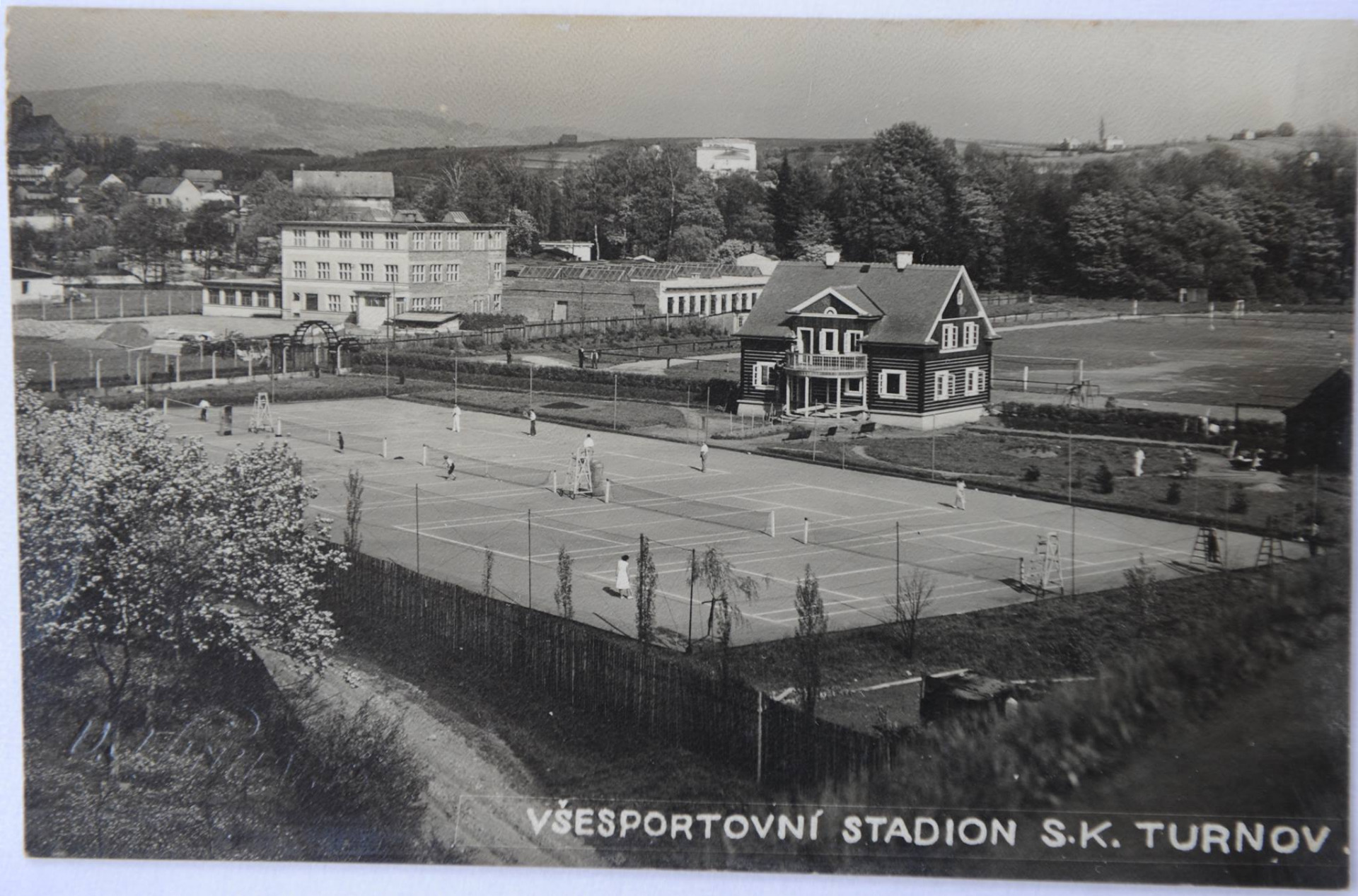 Tentokrát jsme vybrali sportovní tematiku, konkrétně pohlednici se všesportovním stadionem S. K. Turnov z první poloviny 20. století. Na obrázku můžete vidět tenisový a fotbalový areál, vedle kterého se nacházela továrna Jana Ouhrabky, dnešní budova Preciosy. Slavnostní otevření areálu proběhlo roku 1931 a od té doby toto místo prošlo několika úpravami. Za zmínku například stojí vytvoření motocyklové dráhy kolem fotbalového hřiště a výstavba tribuny. Svojí současnou podobu poté areál začal dostávat od 70. let 20. století. Foto: Linhart V. J. Zdroj: Muzeum Českého ráje v Turnově