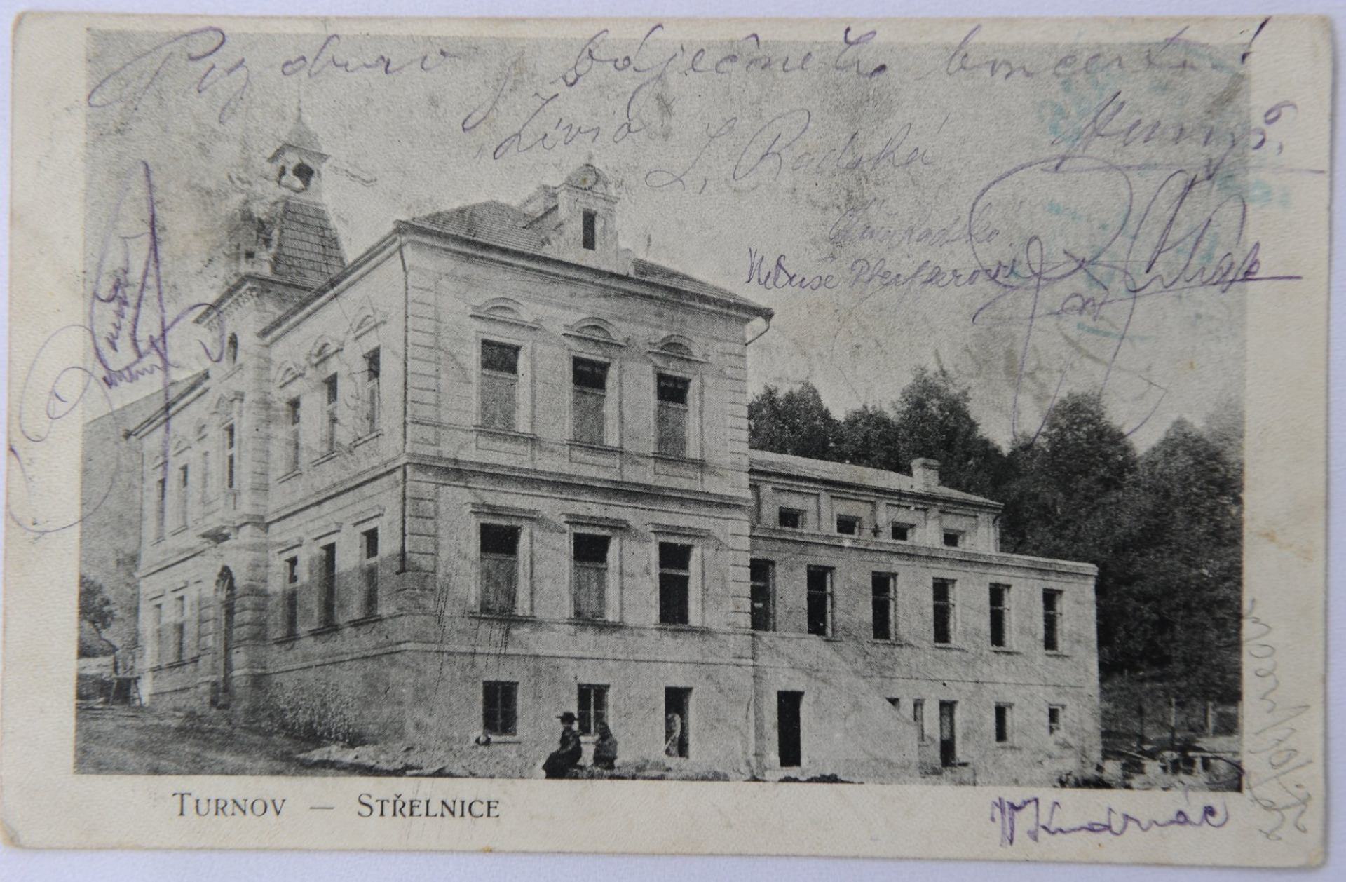 Tentokrát se jedná o historickou pohlednici ze začátku 20. století s původní budovou Střelnice, která sloužila svému účelu necelých sto let. Kromě dřívější podoby budovy je pohlednice unikátní i tím, že je na ní dobře čitelný text „Pozdrav z báječného koncertu!“ a několik vlastnoručních podpisů. Zdroj: Muzeum Českého ráje v Turnově