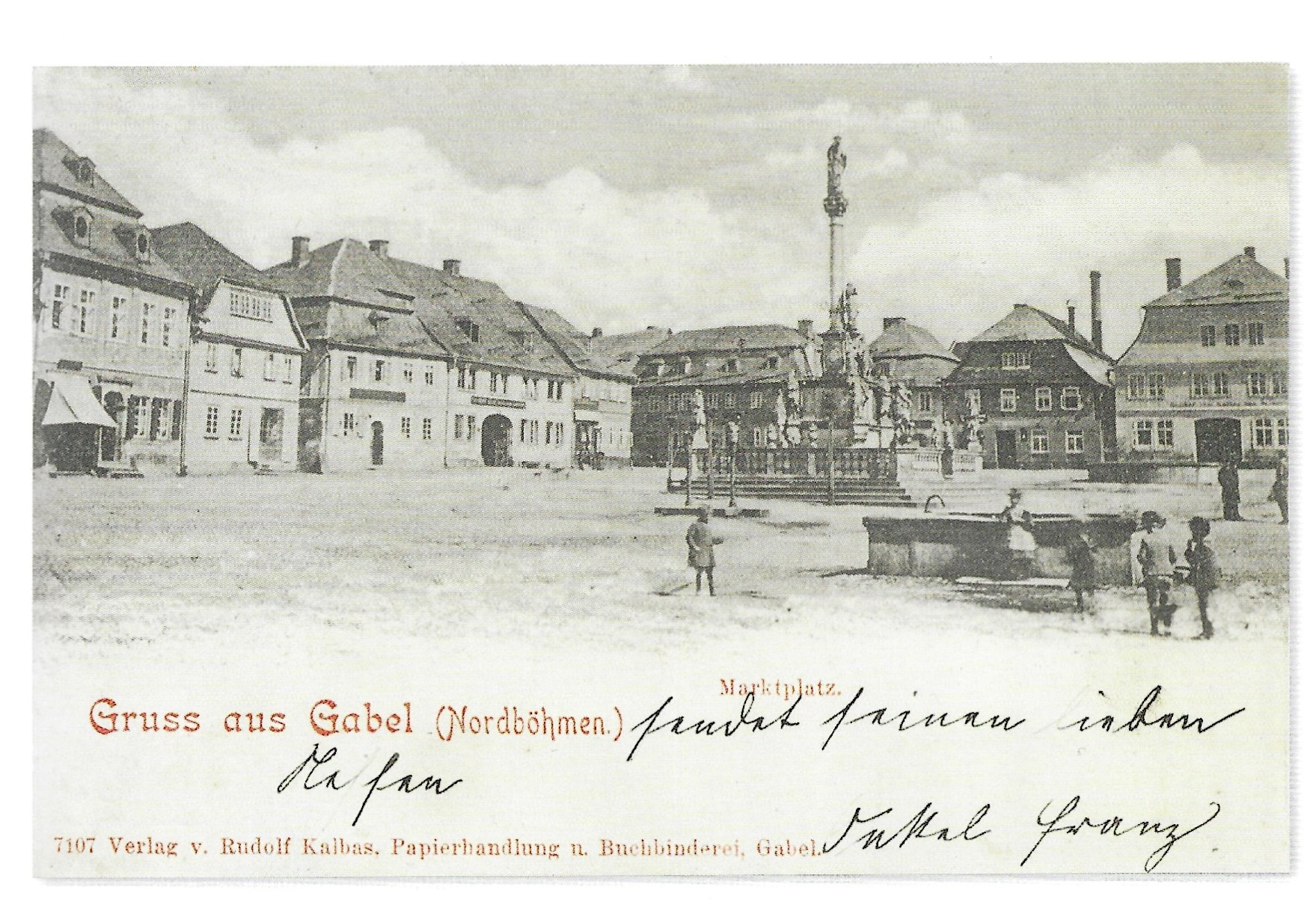 Knihtisková pohlednice Tržního náměstí, v popředí kašna na vodu se skupinkou hrajících dětí. V pozadí obchod s galanterií Reinholda Hoffmanna čp. 157 s dosud nepřestavěným hostincem U Bílého Iva a sousedním domem Petera Henkeho čp. 159. Patrná jsou zejména dvoukřídlá špaletová okna. 1899