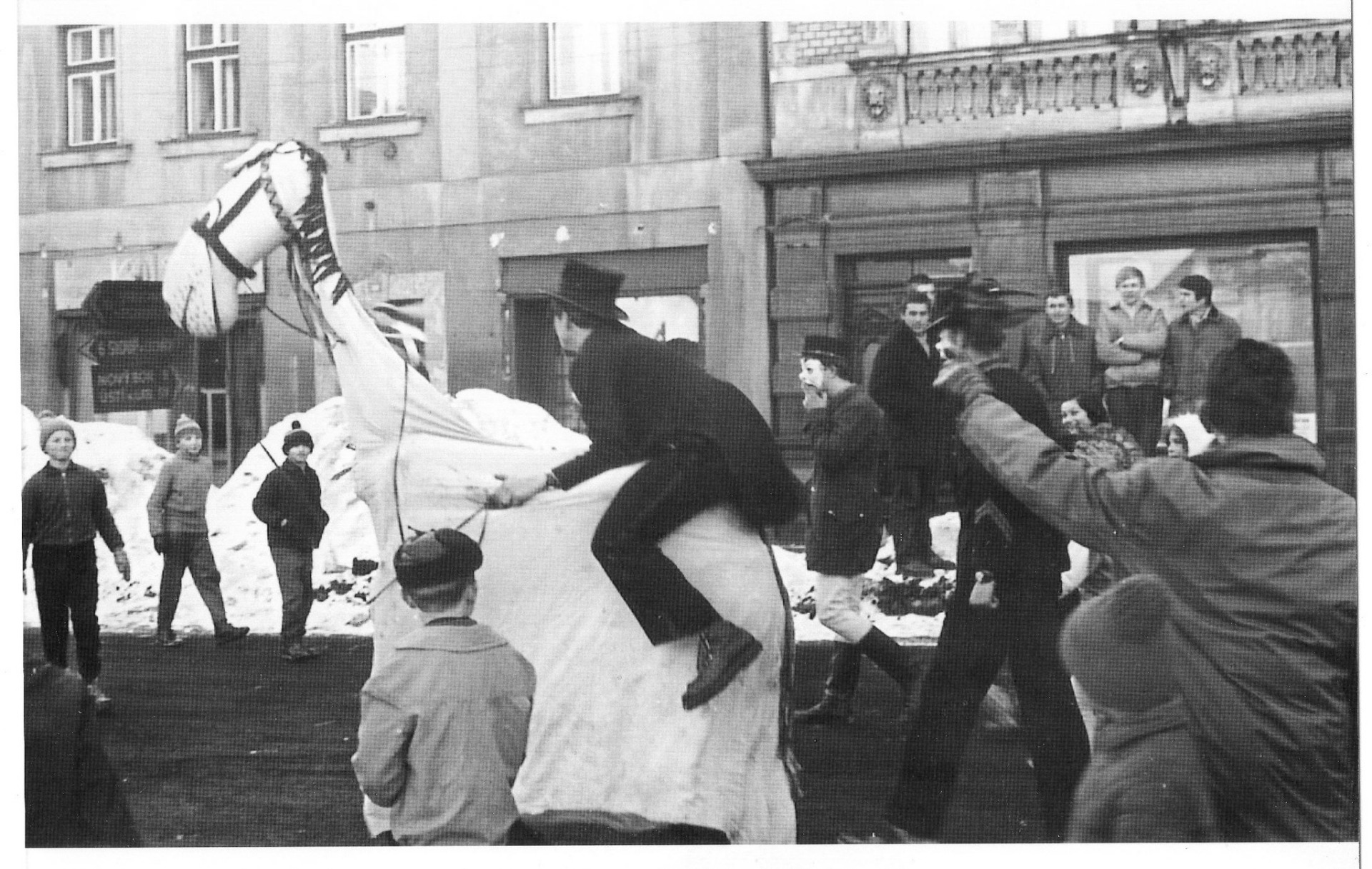 čas masopustů, tak i jedna odsud, ze Cvikova. Snímek pocházející přibližně ze 60.let zachycující aktéry před zbořenou západní zástavbou náměstí (vpravo od fotografie stával hotel U Zlatého lva).