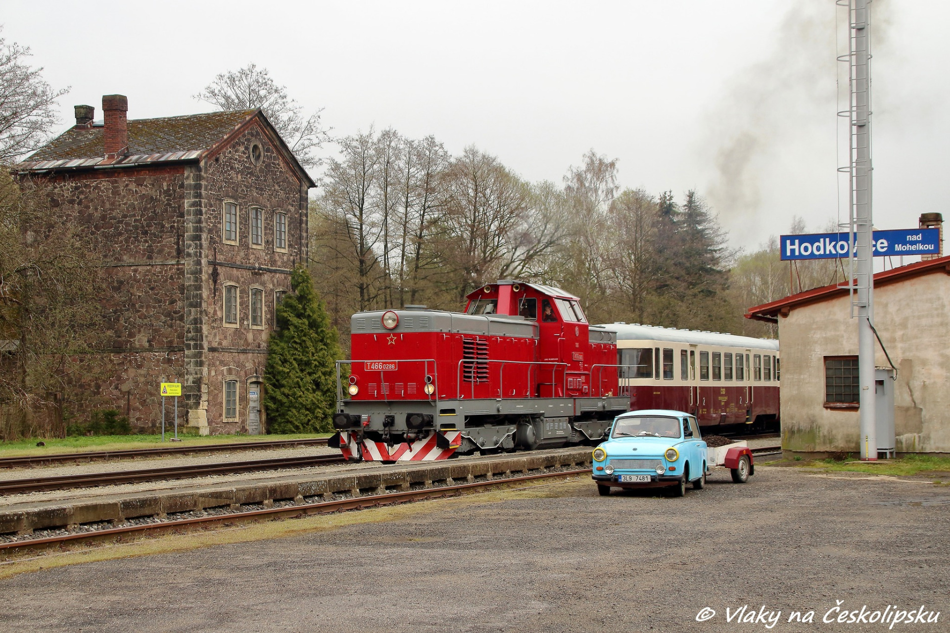 v Hodkovicích nad Mohelkou. Rozjíždějící se „Pielstick“ se svým vlakem projíždí okolo Trabantu 601 s loženým vlekem uhlí. 1.5.2021