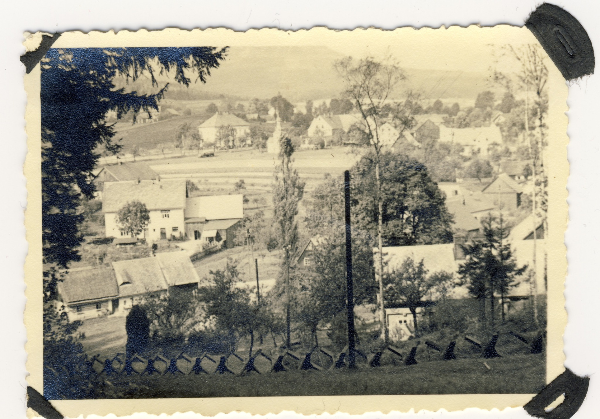 Pohled na Petrovice, vzadu je dobře vidět budova tehdejší školy. Vpředu na snímku pak jsou vidět protitankové překážky, tzv. rozsocháče, či české ježky. Snímek byl pořízen krátce po okupaci našeho pohraničí. (archiv Jaroslav Beneš)