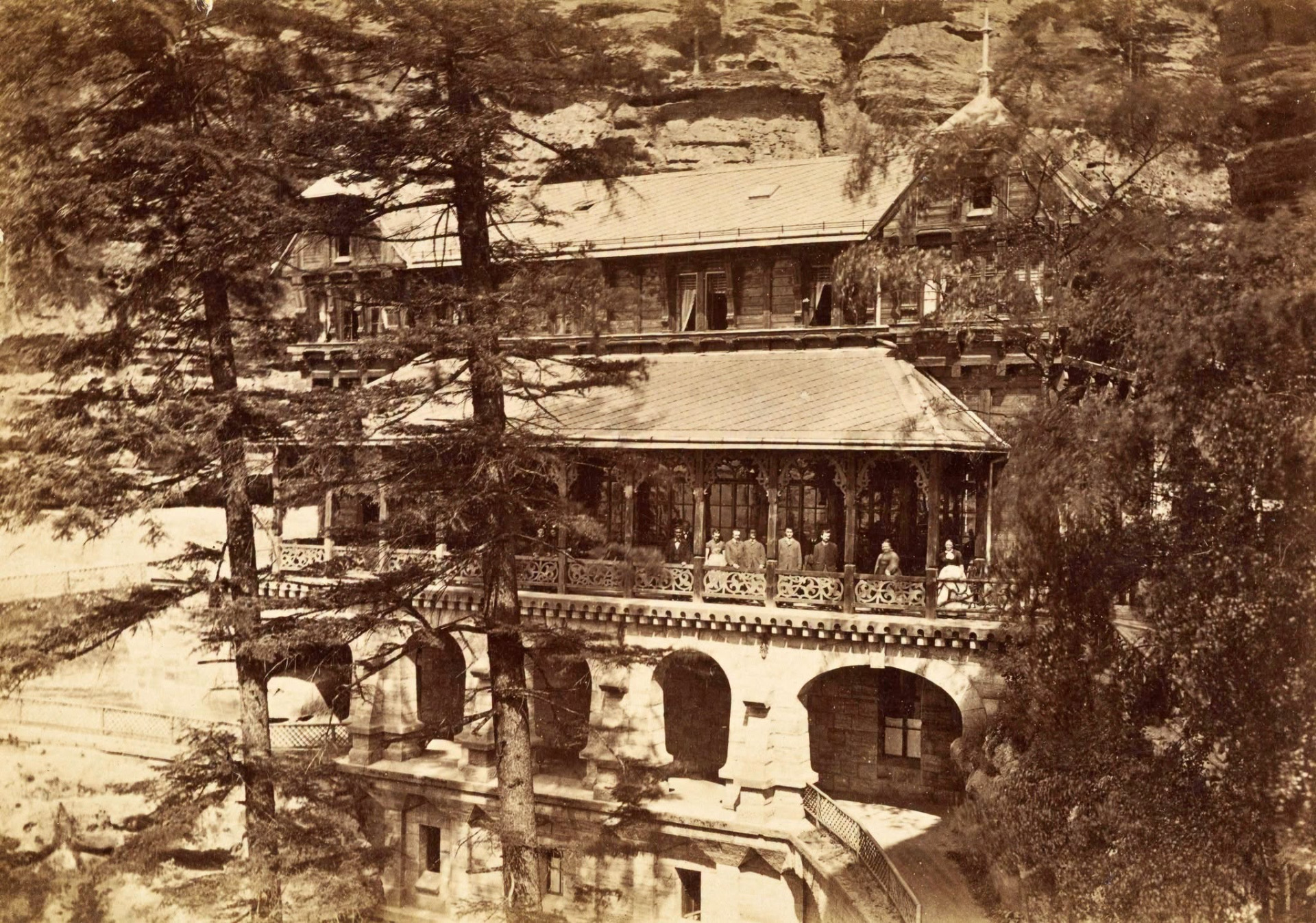 Sokolí hnízdo pod Pravčickou bránou v Českém Švýcarsku - 1885 Zámeček byl postaven v roce 1881 knížetem Edmundem Clary-Aldringenem na místě dřívějšího malého občerstvení. Dobová fotografie od fotografa R. Halma ukazuje tehdejší podobu budovy s kamenným přízemím a dřevěným patrem s vyřezávanou verandou. Foto: Robert Halm (1828-1910) (archiv J.Peterka)
