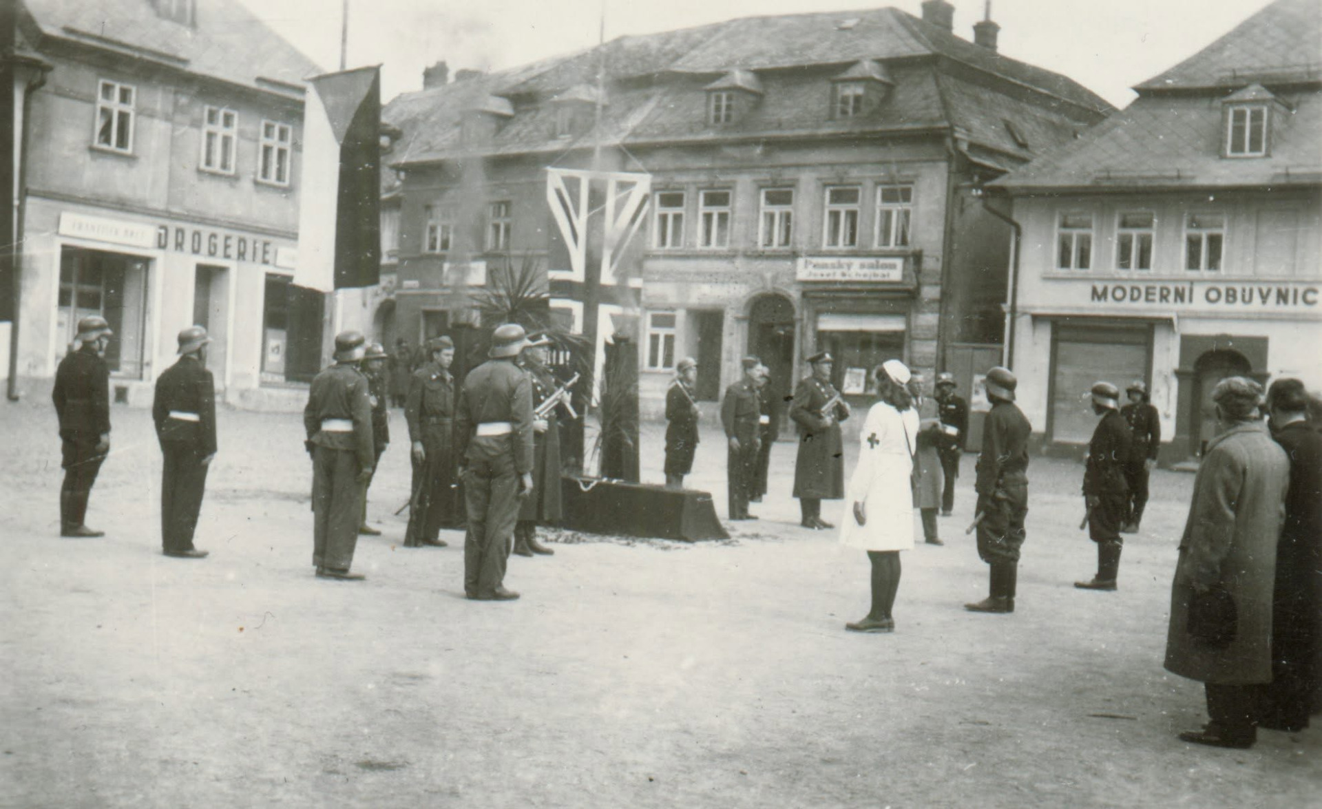 Přikládám fotografii z jakési tryzny, která se konala v Jablonném na náměstí někdy po válce. Mám několik fotografií z této akce, ale léta jsem nepřišel na to, o jakou akci šlo. Na snímku jsou hasiči v přilbách a finanční stráž se samopaly. Z vlajek tam byla ještě sovětská - vykukuje zcela vlevo a nad symbolickým katafalkem vystupuje dým. (Jaroslav Beneš)